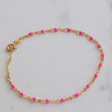 14k gold pink beaded bracelet on a marble surface, showcasing a delicate design with blush pink beads and gold accents.