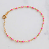 14k gold-filled pink beaded bracelet on marble background, showcasing delicate blush pink beads and adjustable chain design.