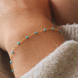 Close-up of a 14k Gold Turquoise Beaded Bracelet worn on a wrist, showcasing its delicate design and ocean-inspired color.