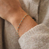 Close-up of a 14k Gold-Filled Turquoise Beaded bracelet on a wrist, showcasing ocean-inspired color.