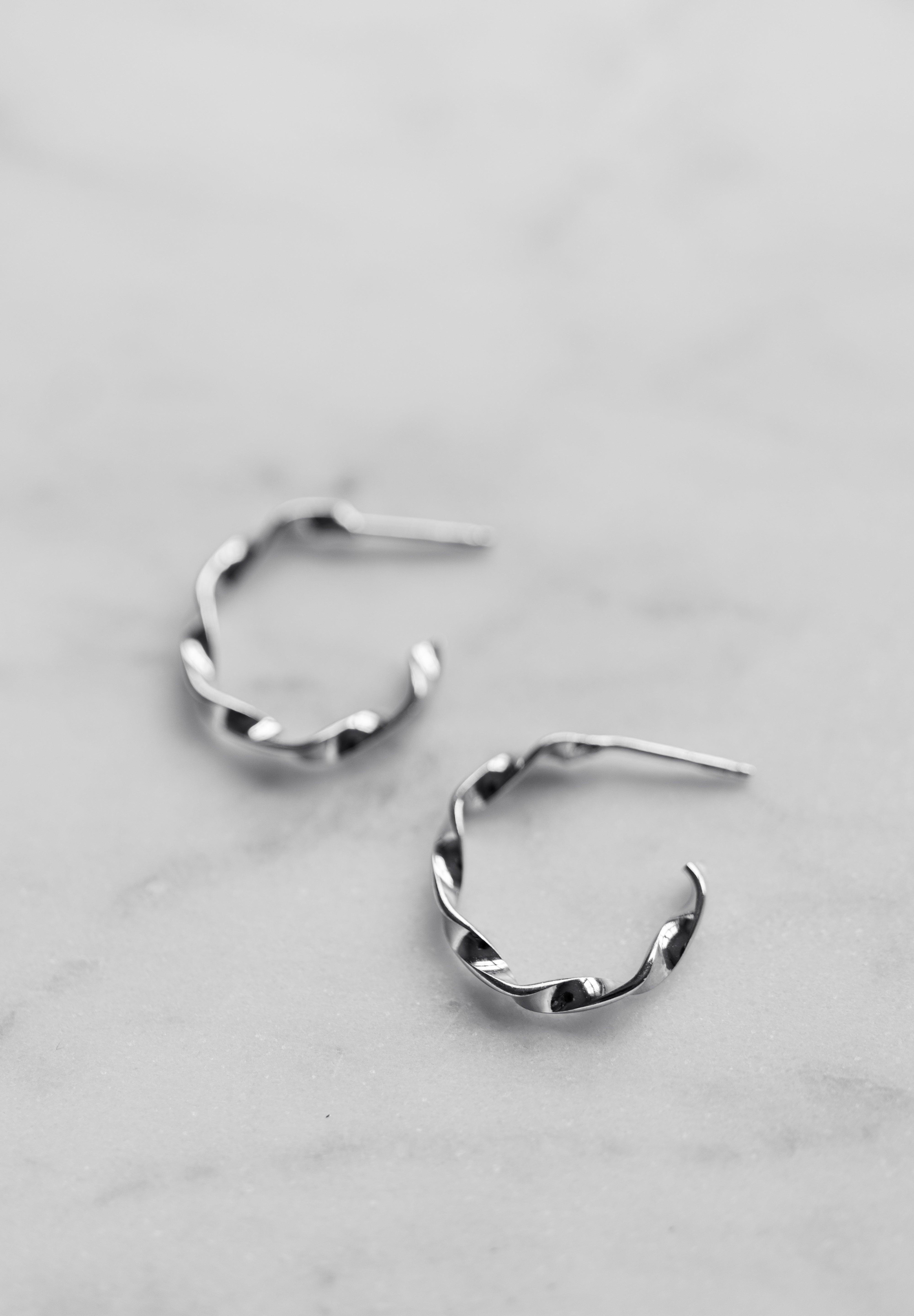 Pair of silver hoop earrings on a light gray background