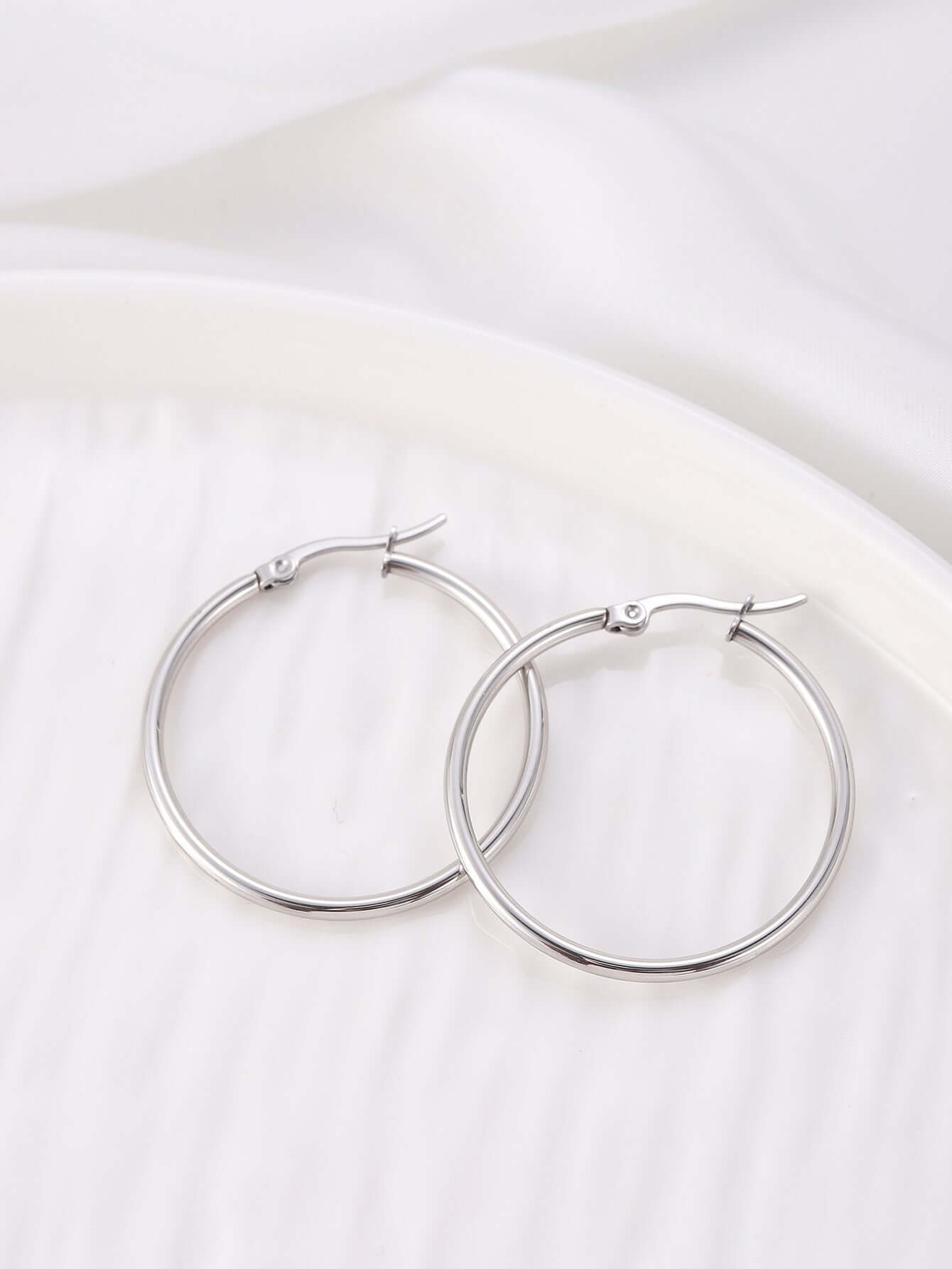 Elegant silver hinged hoop earrings in a minimalistic design, perfect for a chic and comfortable accessory.