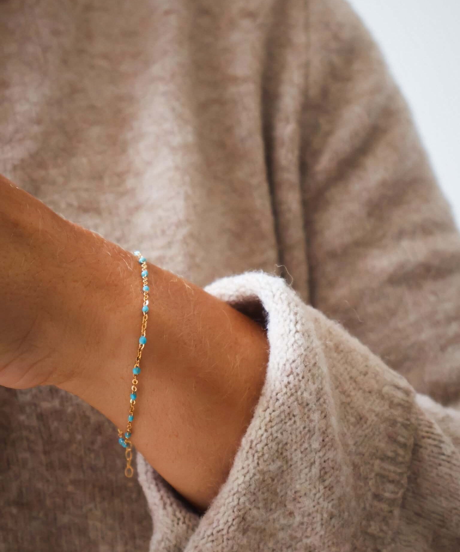 Close-up of a wrist wearing a 14k Gold Turquoise Beaded Bracelet, showcasing its ocean-inspired colors and delicate design.