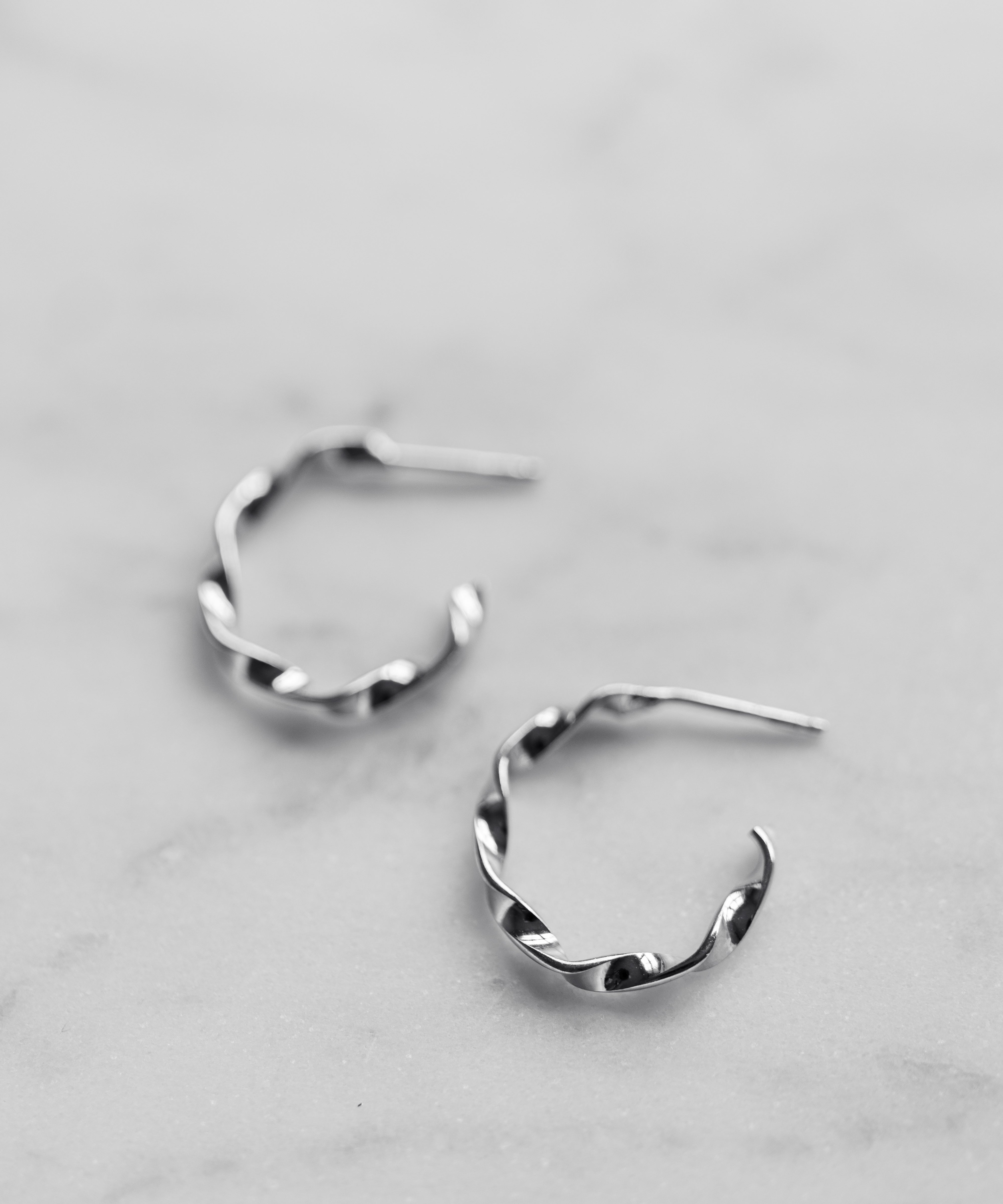 Pair of silver hoop earrings on a light gray background
