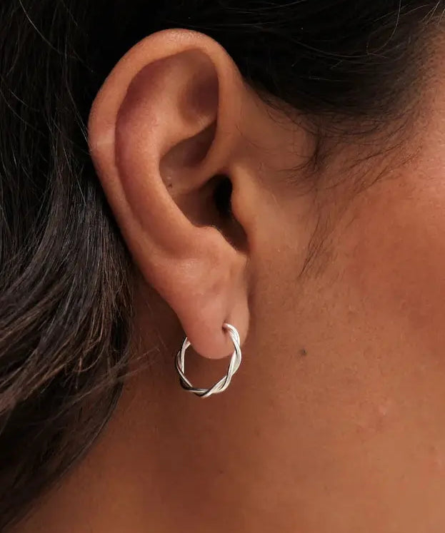 Close-up of a model wearing 20mm Sterling Silver Twisted Rope Hoop Earrings, showcasing elegant style and sophistication.