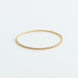 Gold bracelet on a light gray background