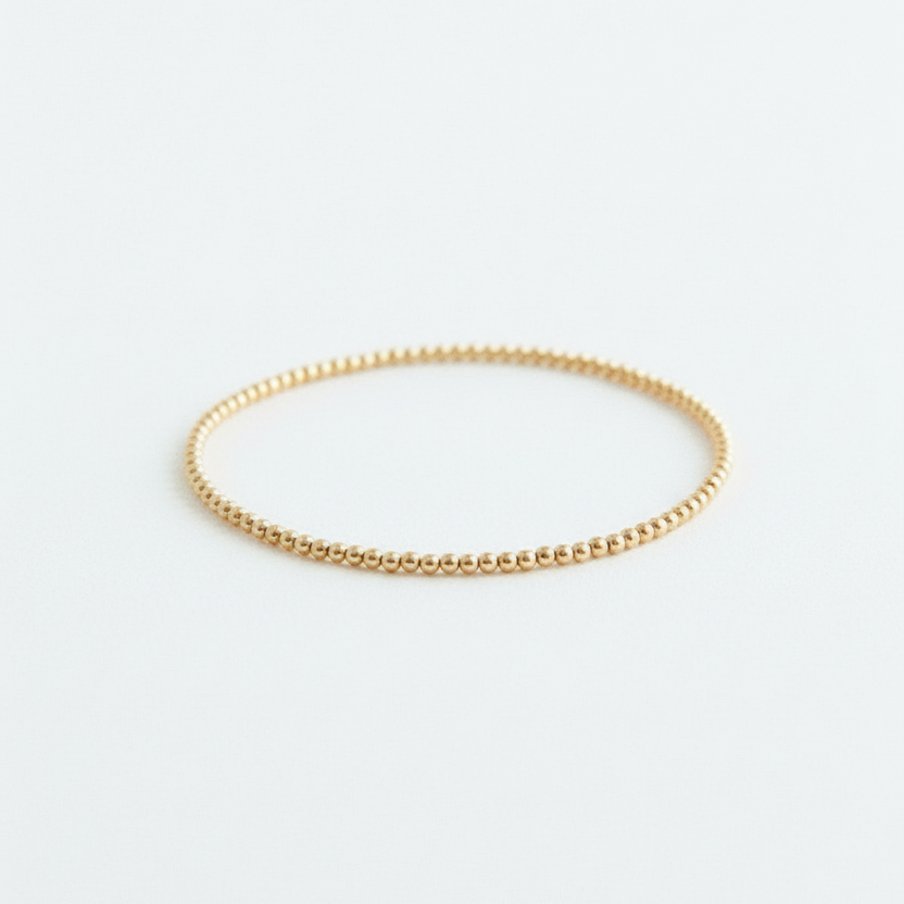 Gold bracelet on a light gray background