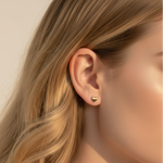 Close up of blonde woman wearing gold heart stud earrings