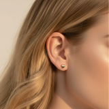 Close up of blonde woman wearing gold heart stud earrings