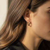 Woman with brown hair wearing gold hinged hoops