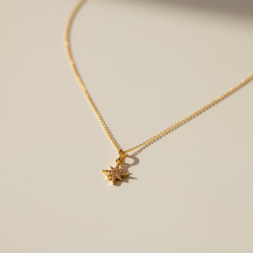 Gold necklace with a star-shaped pendant on a beige background