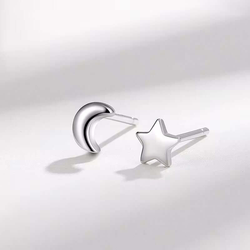 Sterling silver stud earrings featuring moon and star designs, perfect for everyday elegance and style.