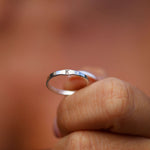 Silver ring with 'K' on a blurred background