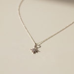 Necklace with a star-shaped pendant on a light beige background