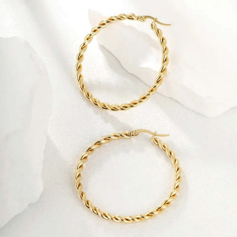 Big gold twisted hoop earrings showcasing a minimalist design, perfect for any occasion.