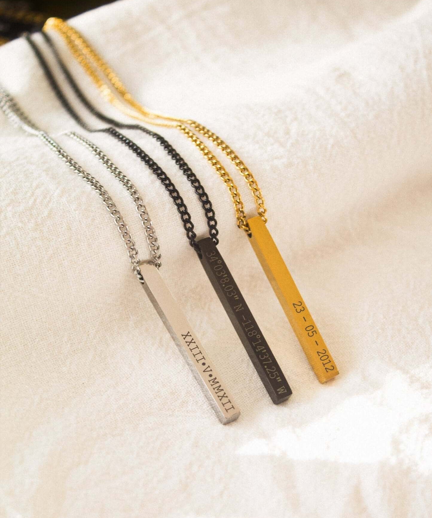 Variety of personalised bar necklaces in gold, silver, and black, showcasing engraved names and dates