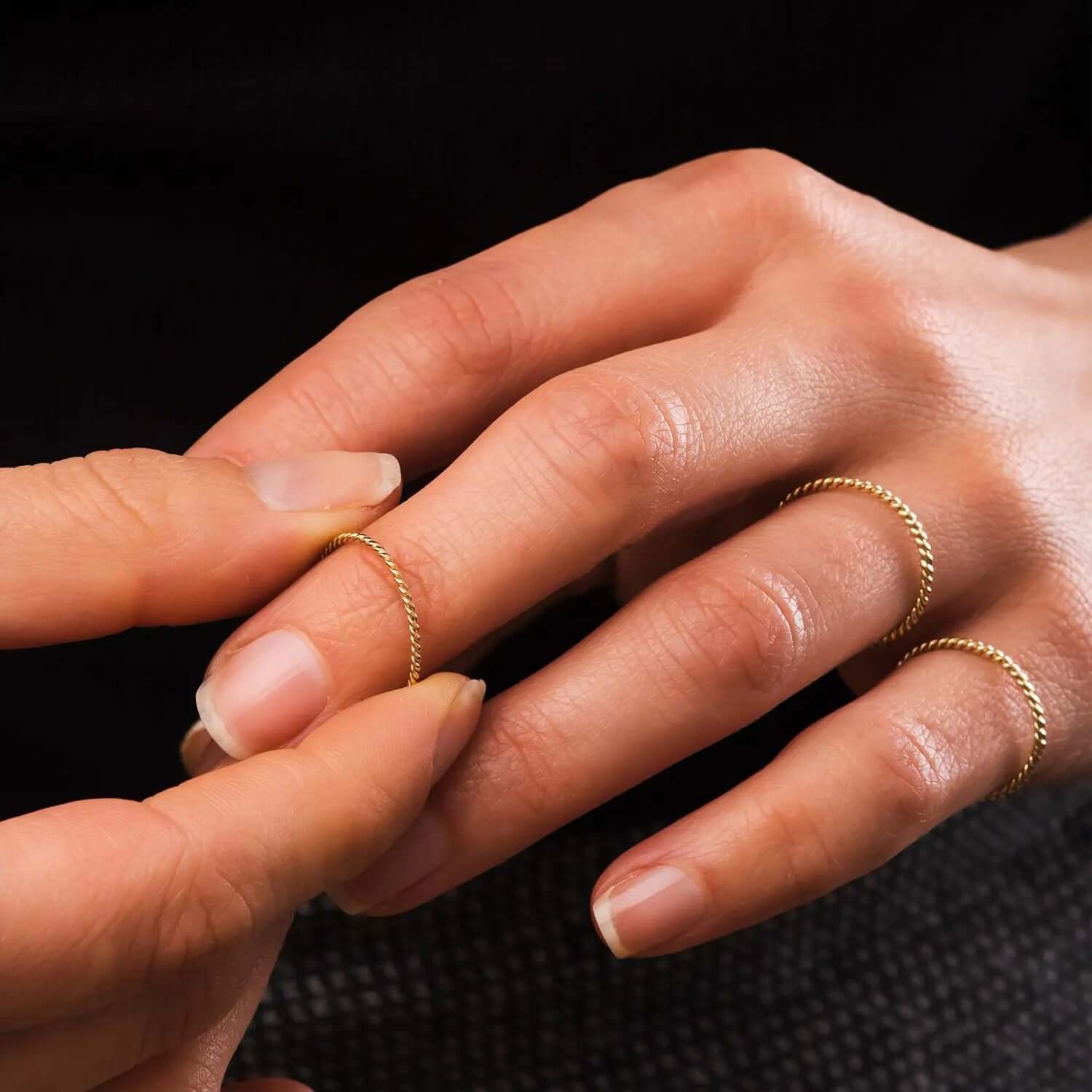 Close-up of hands showcasing a Gold Twisted Stacking Ring, highlighting its elegant design and versatility.