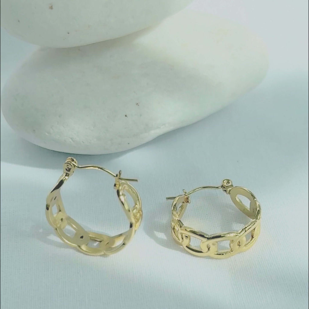 Gold chain hoop earrings resting on smooth stones, showcasing a modern design in high-quality gold stainless steel.