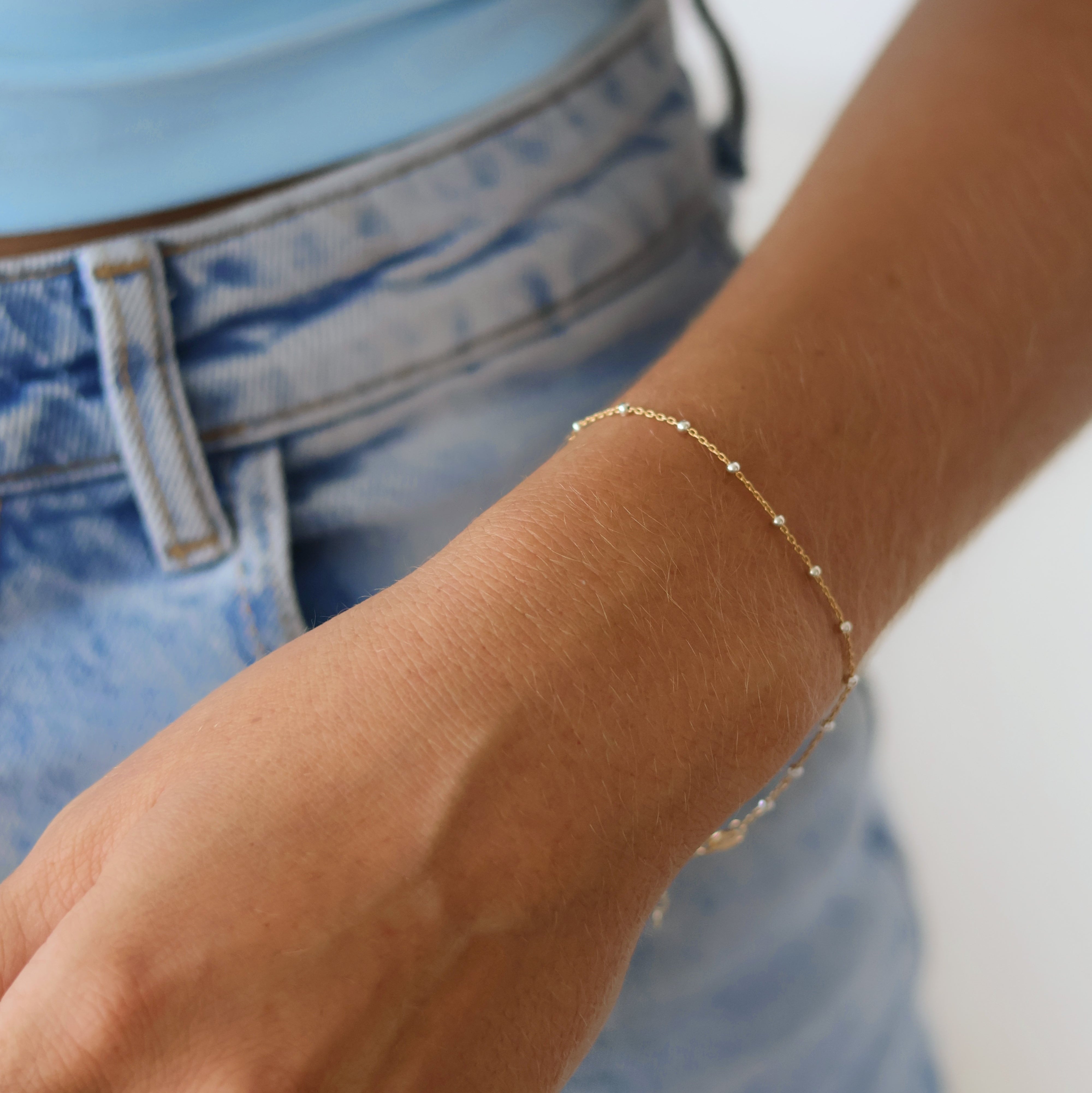 Stylish hand wearing a 14k Gold Satellite Bracelet with Sterling Silver Beads, showcasing mixed metal jewelry trend.