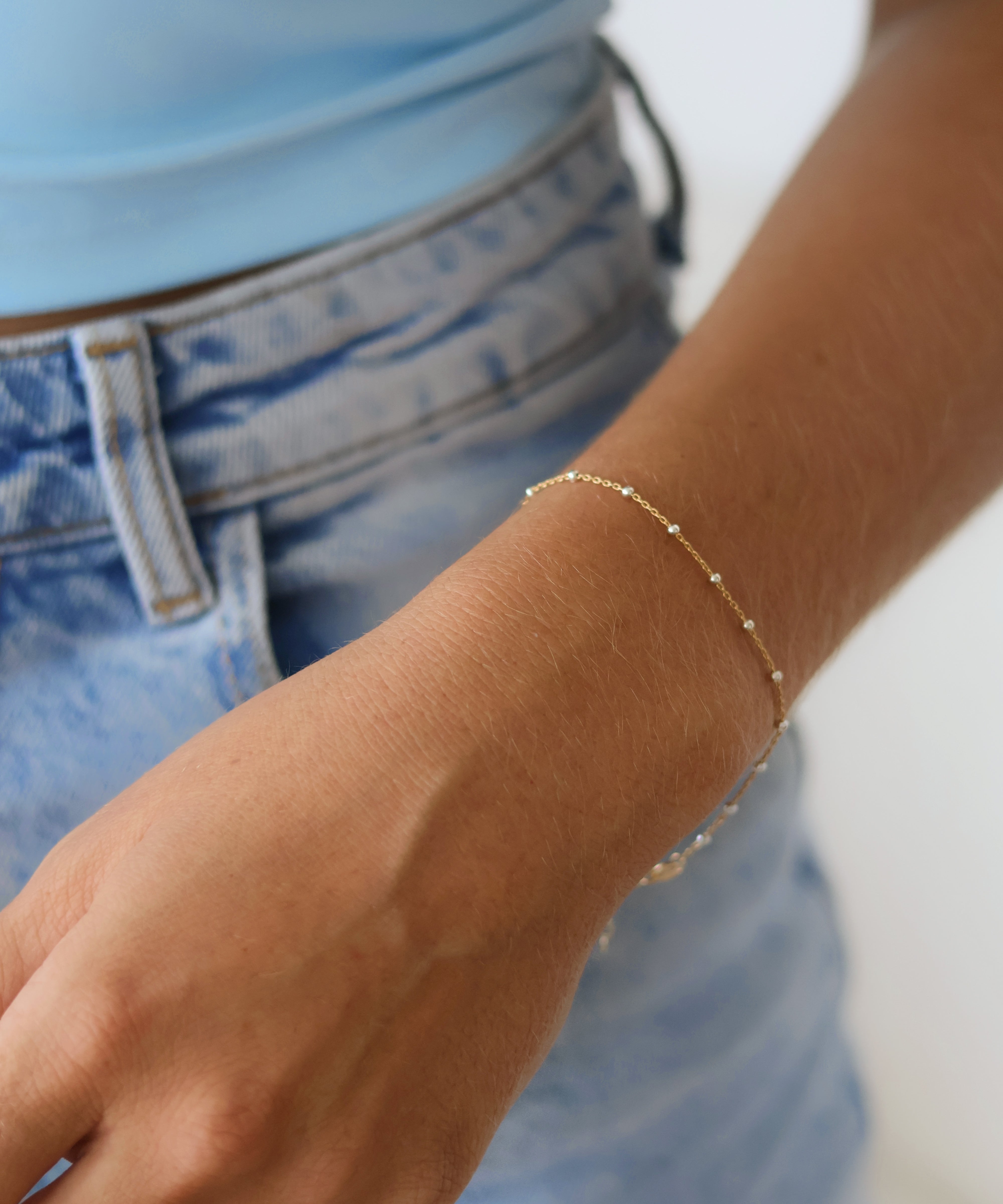 Stylish hand wearing a 14k Gold Satellite Bracelet with Sterling Silver Beads, showcasing mixed metal jewelry trend.