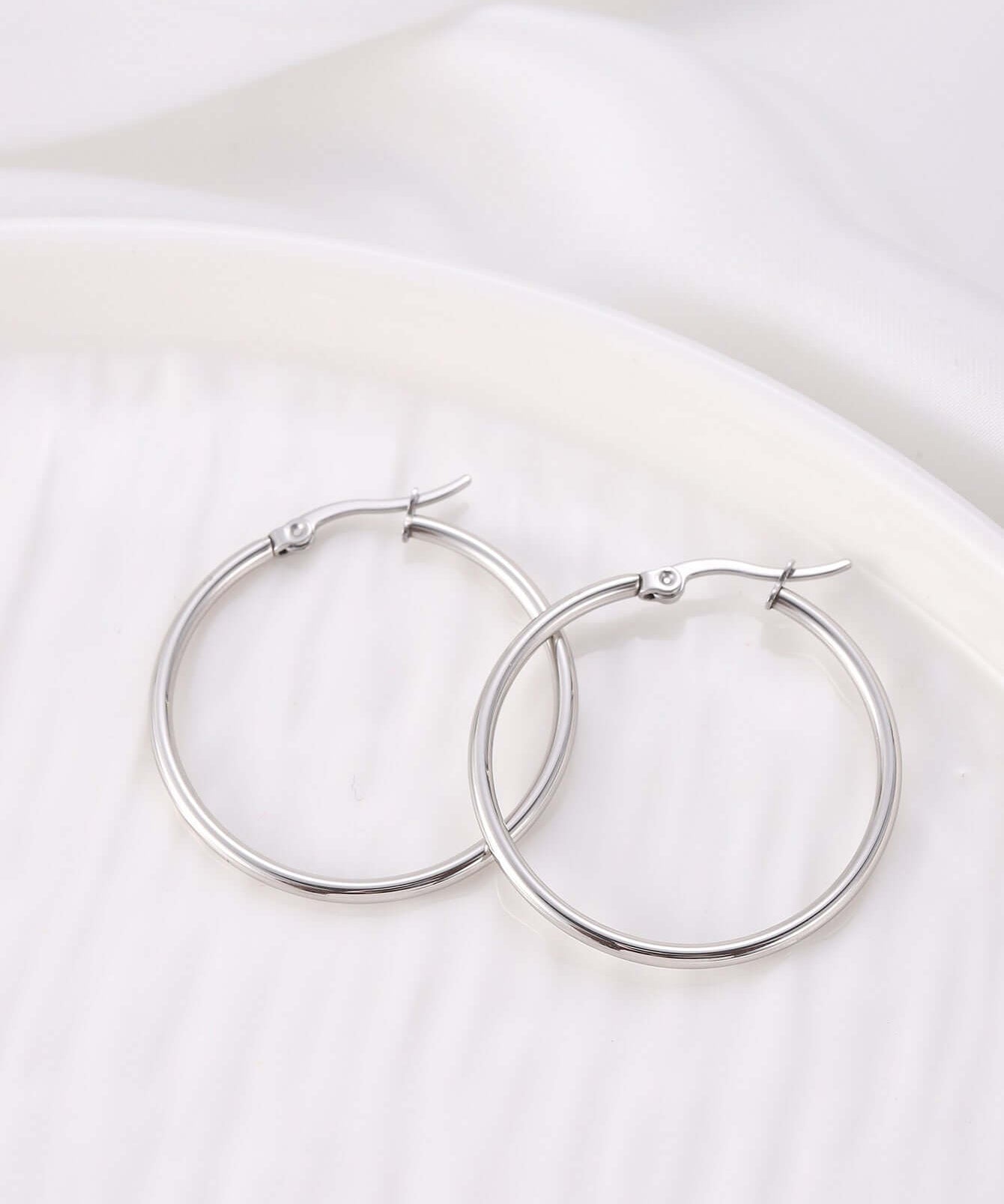Elegant silver hinged hoop earrings in a minimalistic design, perfect for a chic and comfortable accessory.