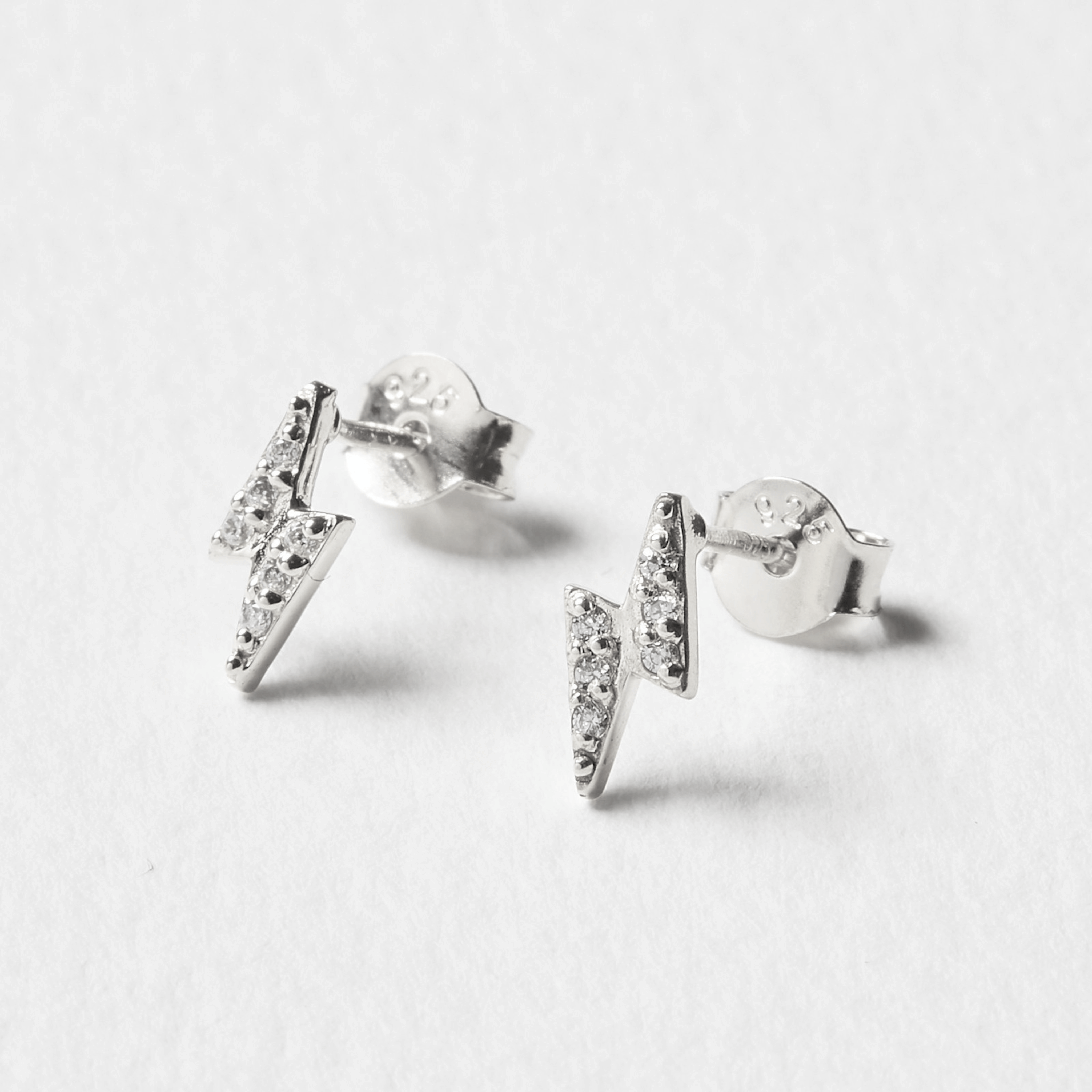 Sterling silver lightning bolt stud earrings with cubic zirconia inlay, perfect for adding sparkle to any outfit.